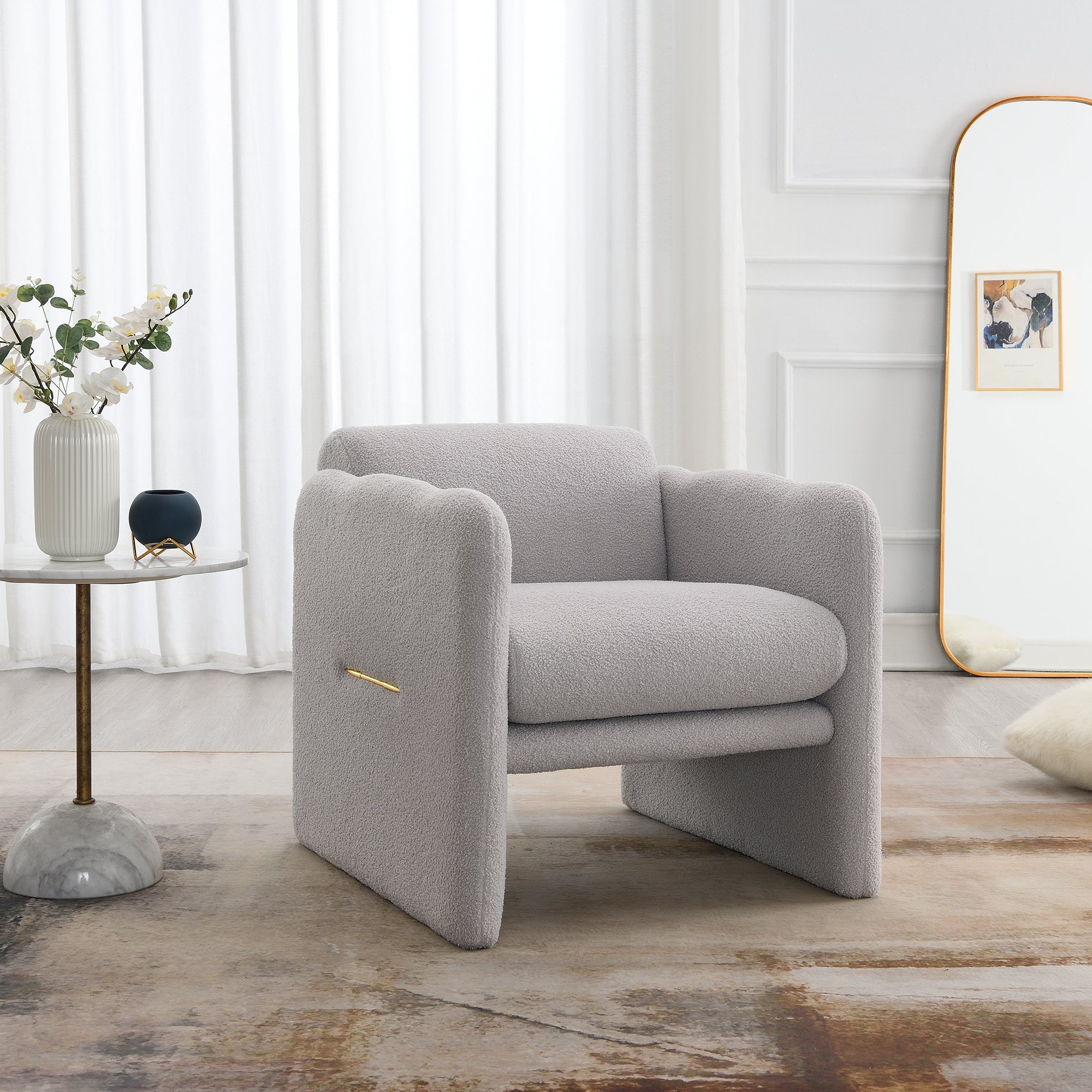 Fauteuil avec accoudoirs ondulés, décorations métalliques de part et d'autre des accoudoirs, en tissu Teddy, gris clair